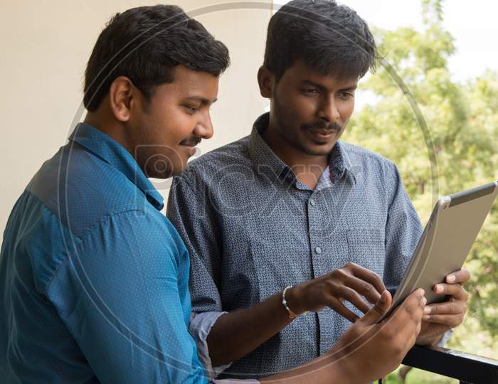 A Couple Of Young Indian Men's Using Tablet Gadget or iPad