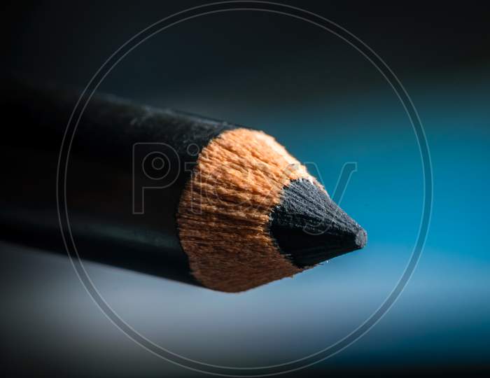 A Macro Shot Of A Black Pencil Tip. Kept In A Blue Background