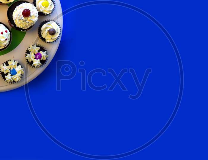 Cup Cakes in served in a Plate isolated with blue Background