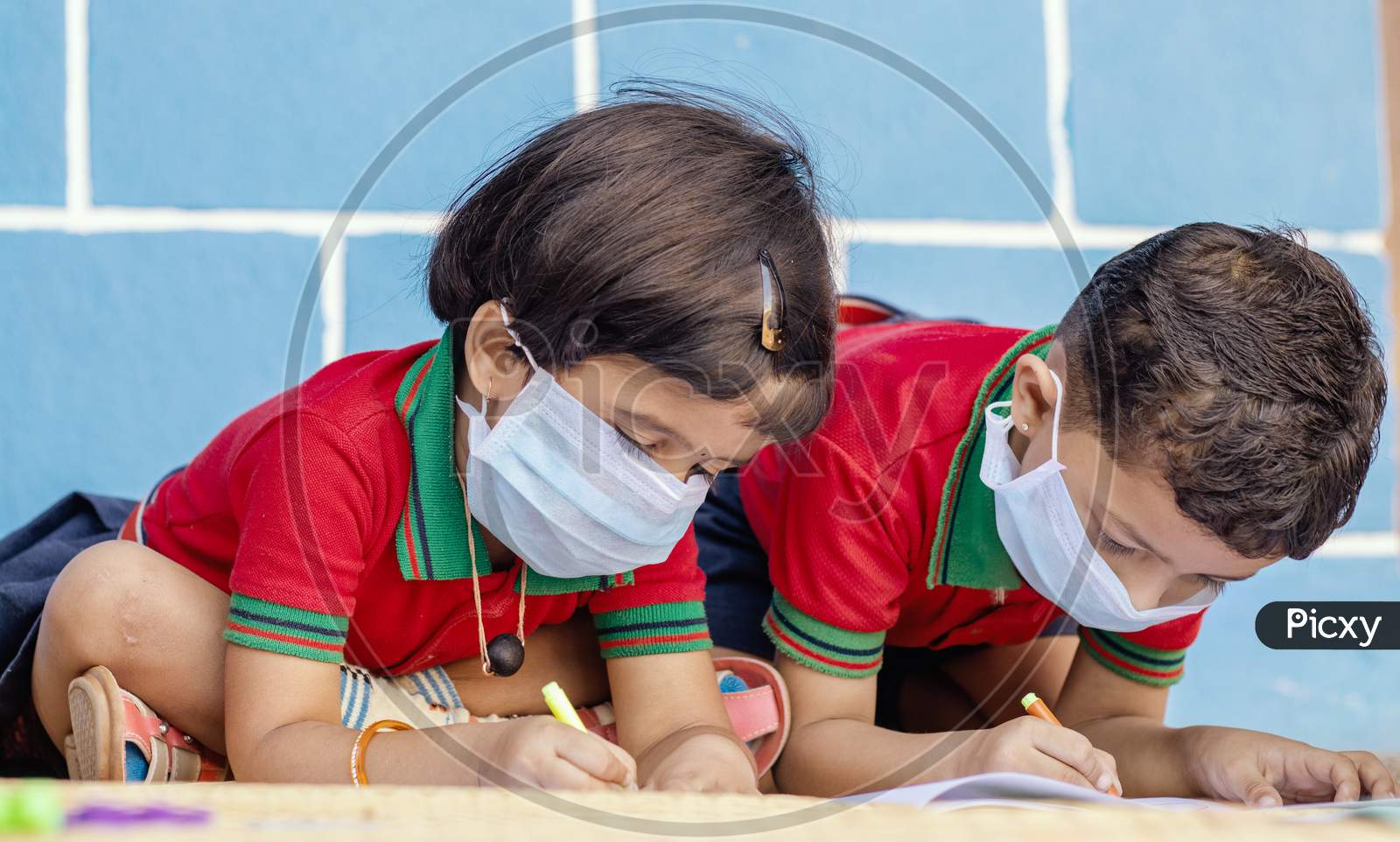 Kids Busy In Writing With Medical Face Mask Wearing Due To Covid-19 Or Coronavirus Outbreak Or Pandemic At School - Children Painting At Home During Lockdown.