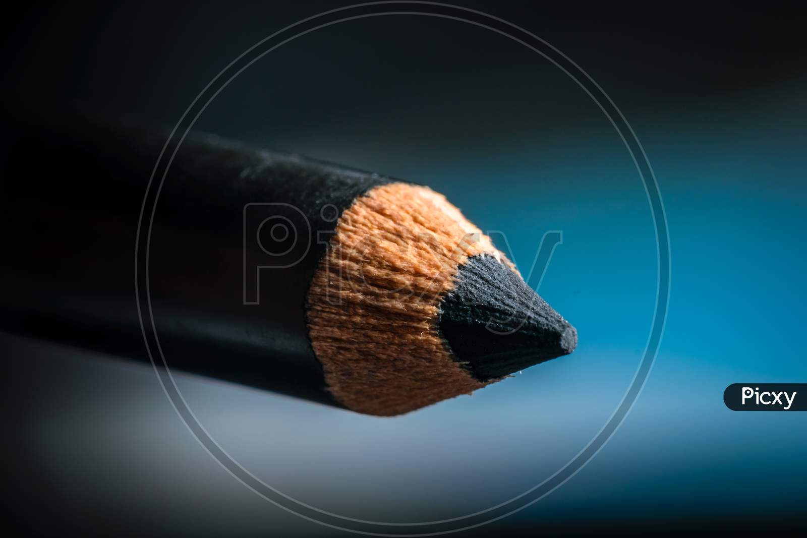 A Macro Shot Of A Black Pencil Tip. Kept In A Blue Background