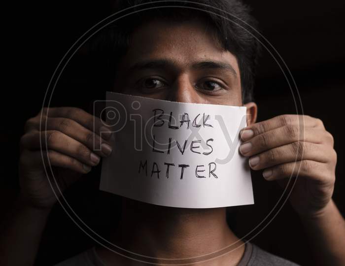 Young Man'S Face Covered With Black Lives Matter Paper Poster - Concept Of Racial Discrimination Against Black People.