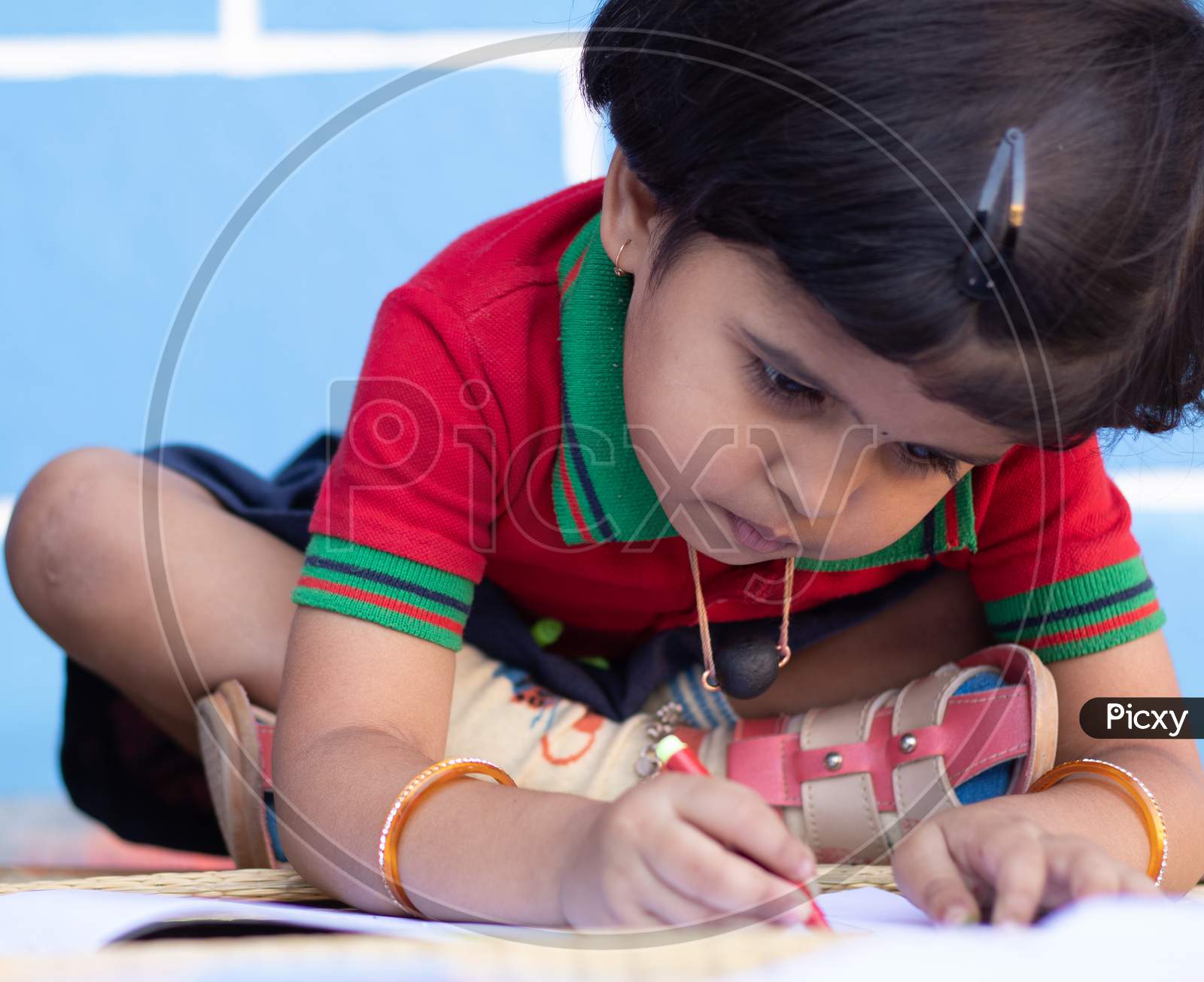 A Kid in School dress is Busy In Writing At School