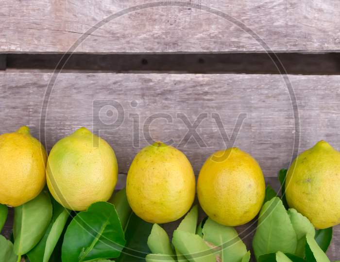 Lemons And Oranges With Wooden Background And Copy Space