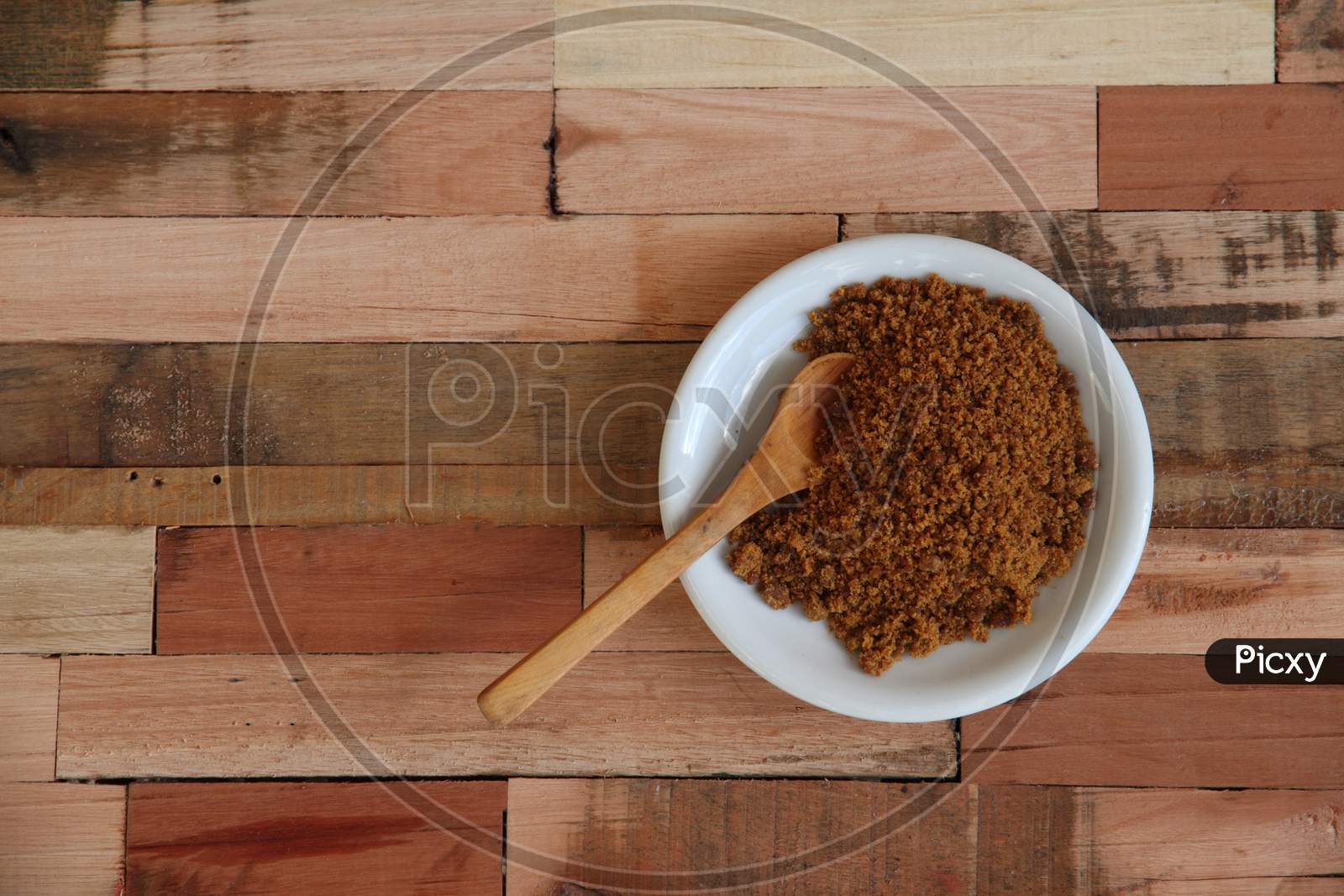 Bowl With Unrefined Brown Sugar On Wooden Background