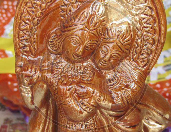 CLOSE UP OF AN INDIAN  WOODEN ART OF A TINY STATUE OF LORD KRISHNA