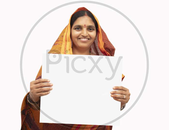 A Happy Indian woman in Traditional Saree showing Plain White Placard isolated with White Background