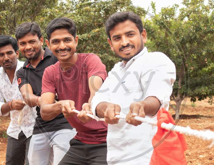 Group Of Happy Young College Students Playing Tug of War Game
