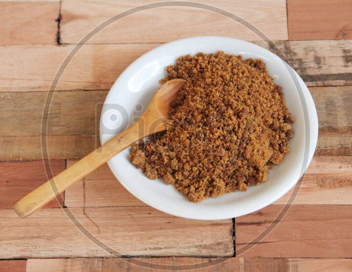 Bowl With Unrefined Brown Sugar On Wooden Background