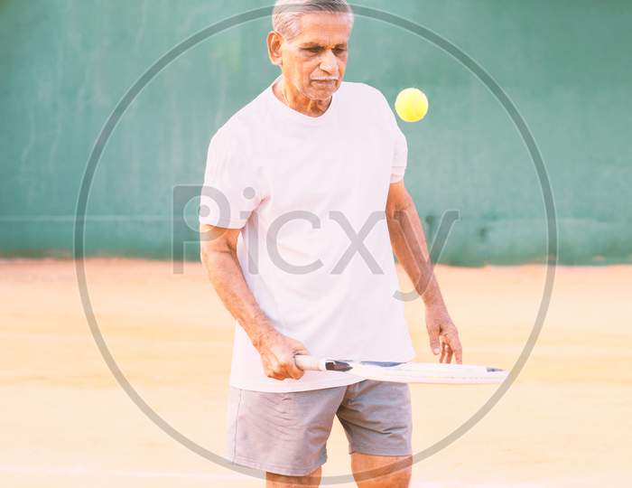 Elderly Man Playing Tennis - Concept Of Healthy And Fit Old People - Senior Player Practicing Tennis.
