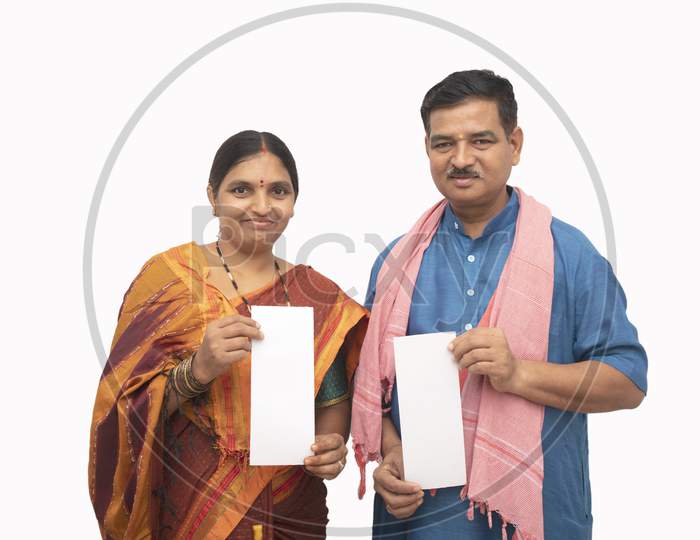 Indian Couple in Traditional Dress holding White Papers in Hand