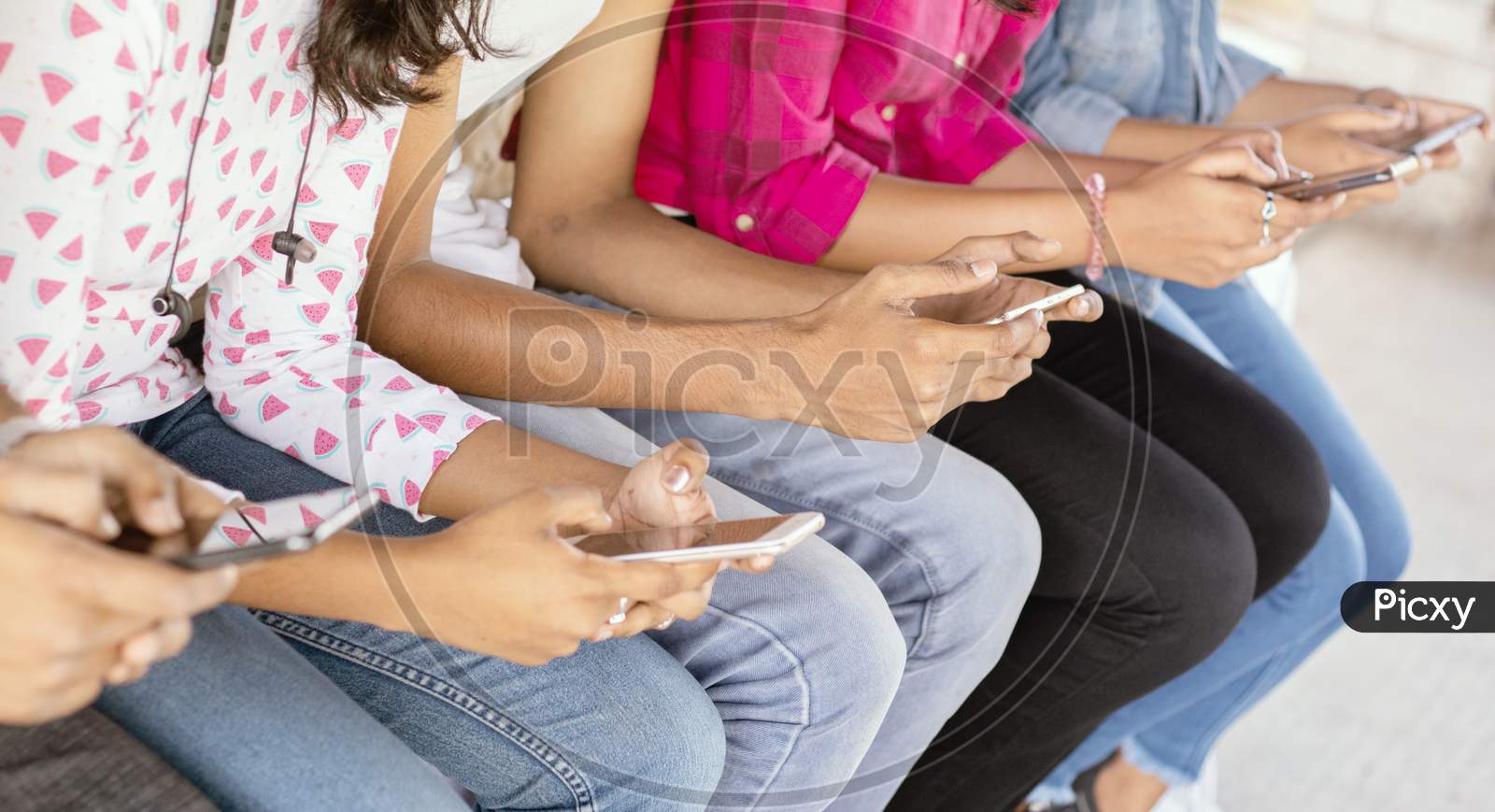 A Group of Young People using Mobile Phone or Smartphone At Outdoors