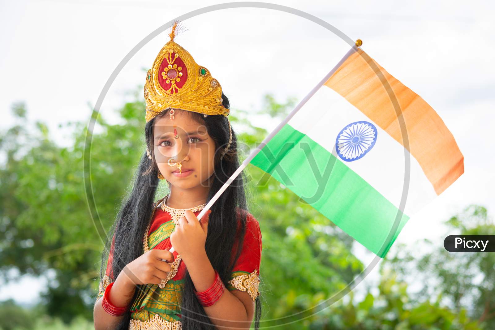 Small Cute Little Indian Girl Kid In Bharat Mata Or Mother India Attire With Indian Flag In Hand.