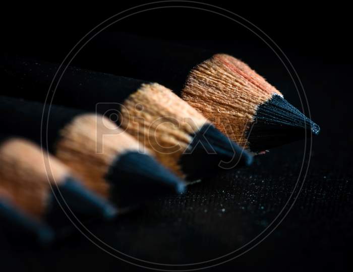A Group Of Pencils Are Kept On A Dark Paper In Ascending Order. Selective Focus On The Tip Of The Distal Pencil