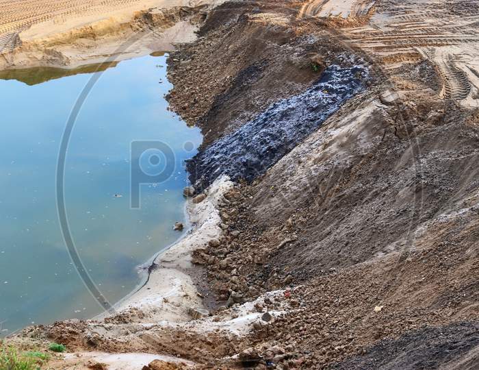 View Into A Gravel Pit With Piles Of Sand And Some Tire Tracks