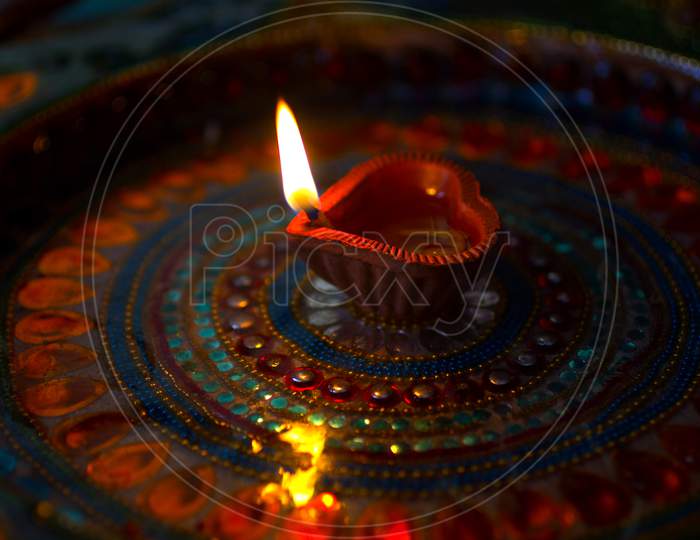 Selective Focus on Lighted Diya / A Concept of Happy Diwali Greetings