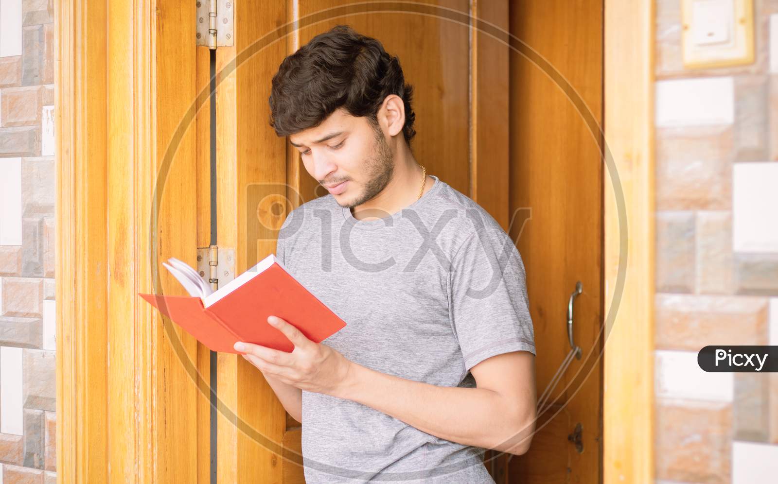 Young Indian Man Reading Book at Home