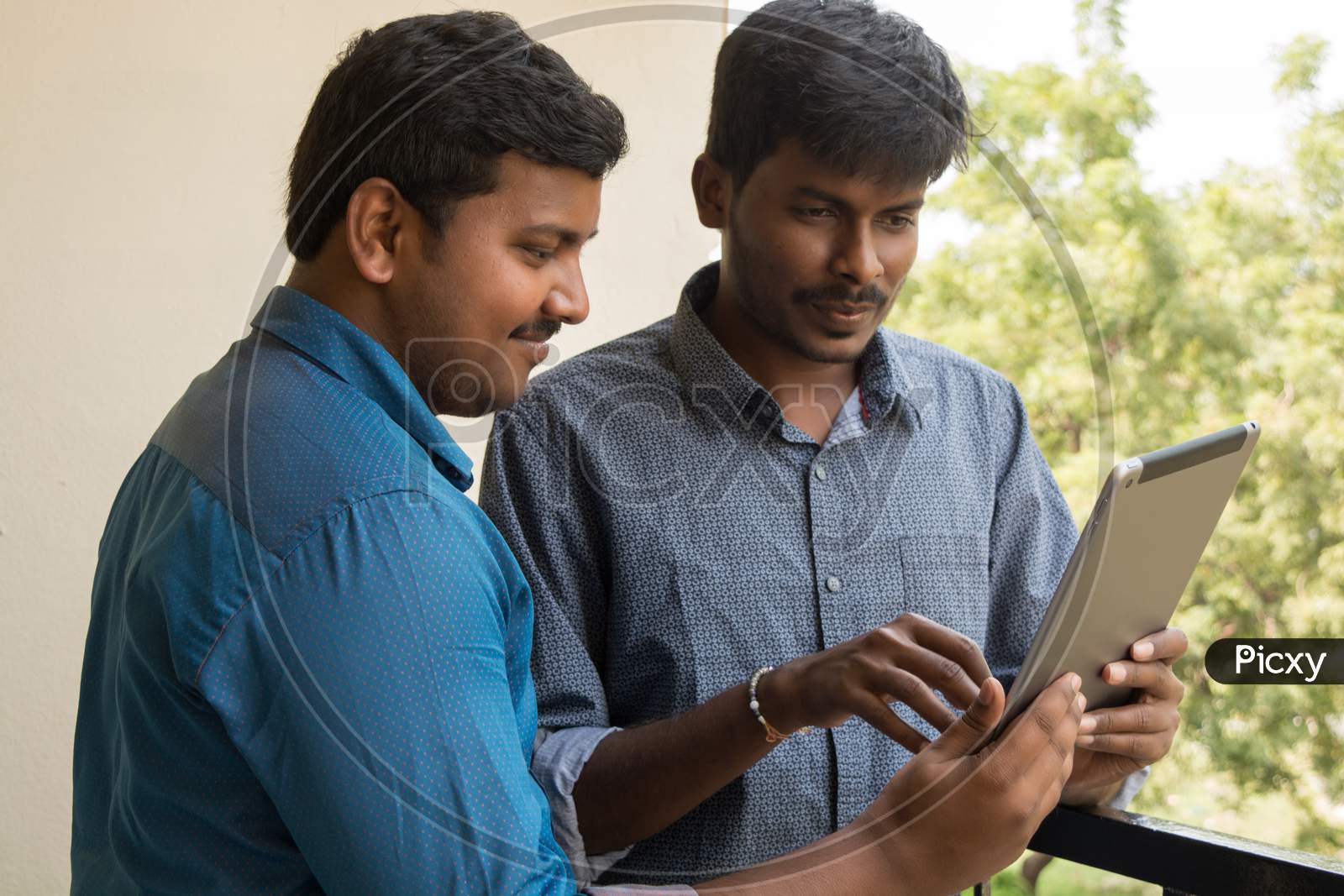 A Couple Of Young Indian Men's Using Tablet Gadget or iPad