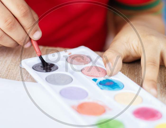 Close up shot of A Kid's Hand Busy In Drawing or Painting At School