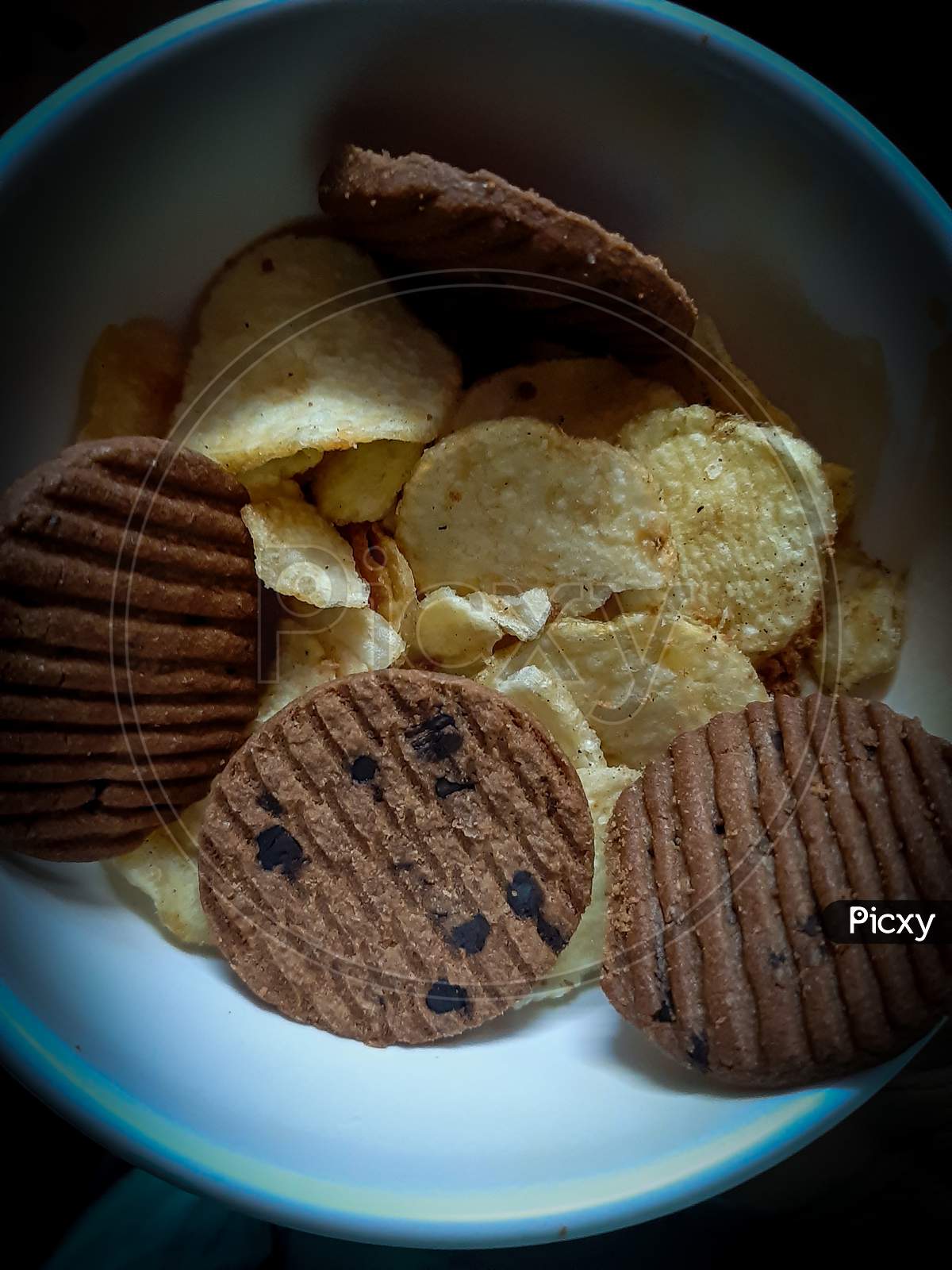 Testy choko biscuit and potato chips with black background.