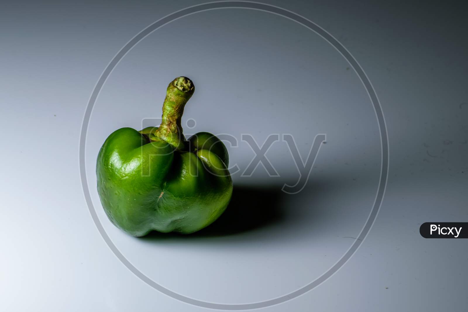 An Isolated Green Capsicum In A White Background And Space For Text In The Right