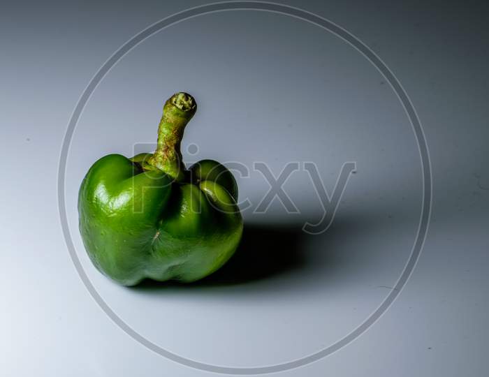 An Isolated Green Capsicum In A White Background And Space For Text In The Right