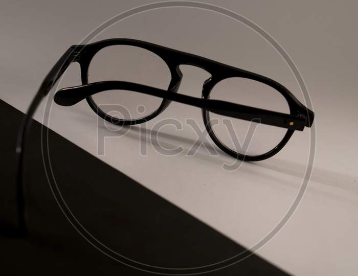 Black frame spectacle (eye glasses) isolated on a black and white background. Photo has empty space for text.