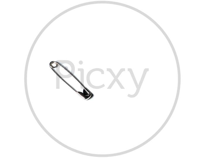 Isolated Safety Pin Placed On A White Background With Space For Text In The Right