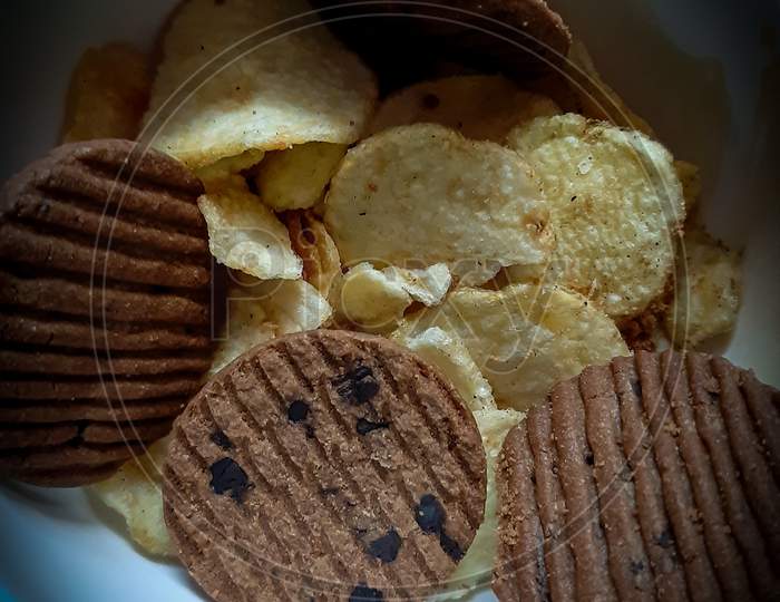 Testy choko biscuit and potato chips with black background.
