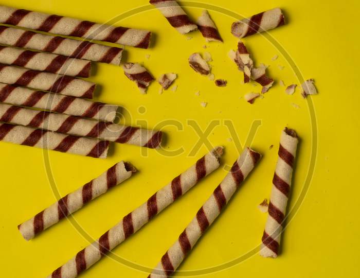 Chocolate Wafer Roll On A Plain Yellow Background