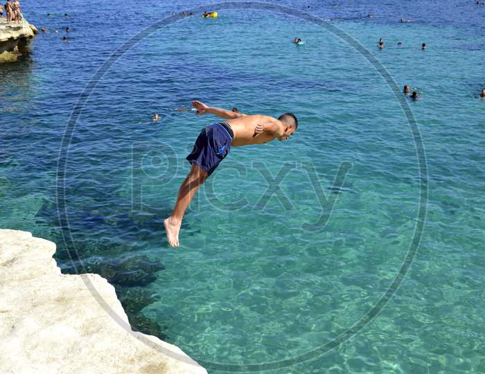 Man diving into the mediterranean sea.  Malta