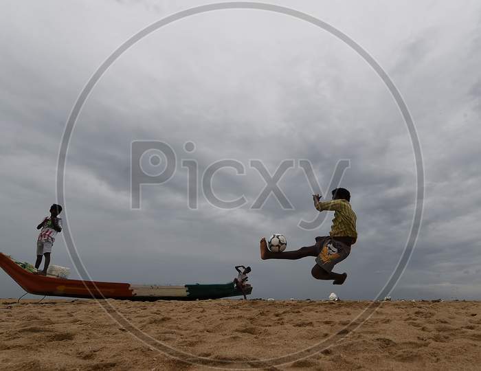 A Boy Plays Football On A Cloudy Day At Marina Beach,Chennai