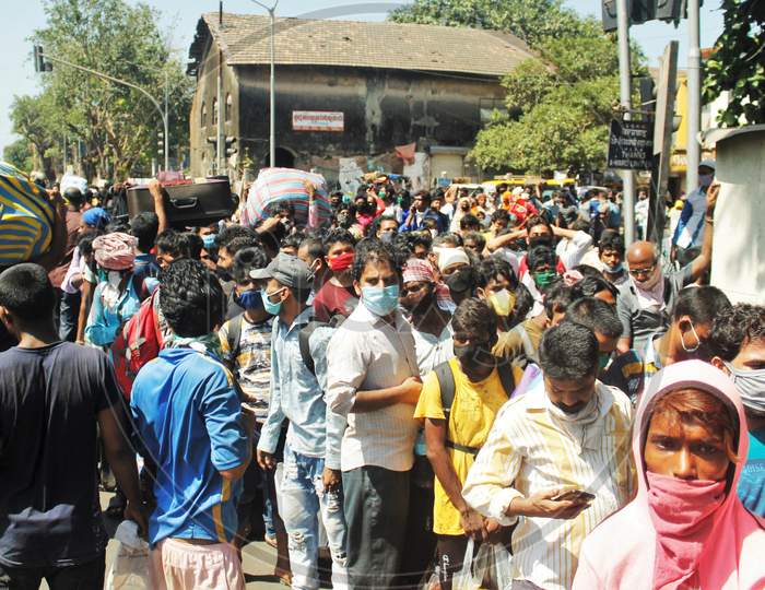 Migrants gather in huge numbers without maintaining social distance waiting to go to Chhatrapati Shivaji Maharaj Terminus (CSMT),  that will take them to their home state during an extended lockdown to slow the spreading of the coronavirus disease (COVID-19), in Mumbai, India, May 30, 2020.