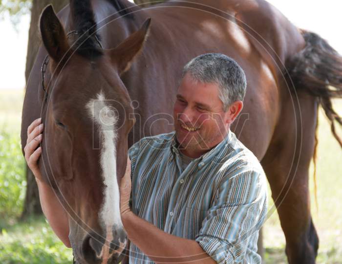 Smiling Man With His Horse In The Argentine Countryside