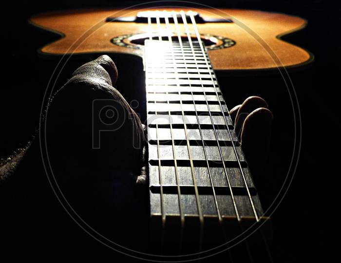 Holding the neck of a guitar
