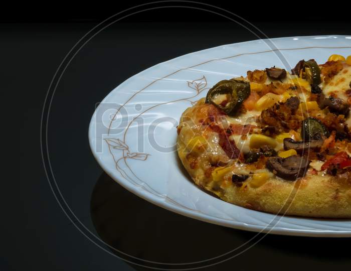 Vegetable Pizza Placed On A White Plate And Kept On A Black Table With Space For Text In The Left