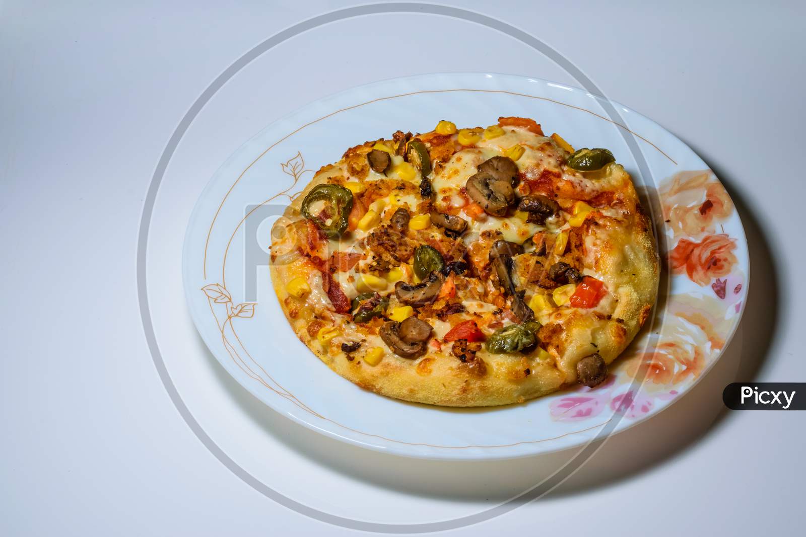 Vegetable Pizza Placed On A White Plate And Kept On A White Table With Space For Text In The Left