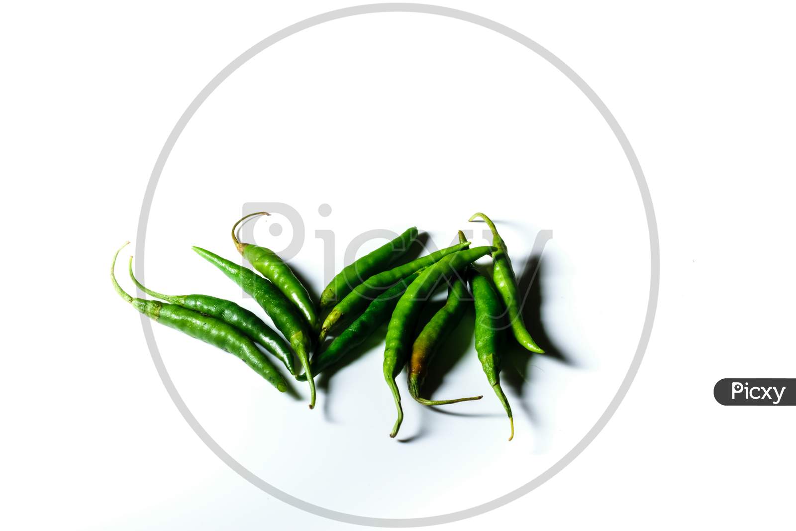Isolated Green Chilis Placed In A White Background With Space For Text In The Right