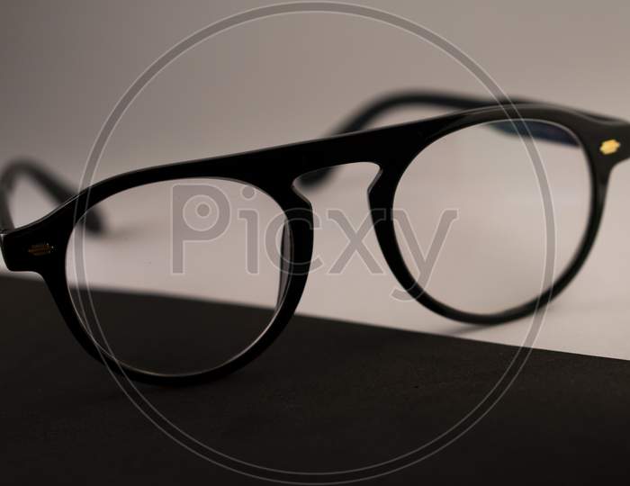 Black frame spectacle (eye glasses) isolated on a black and white background. Photo has empty space for text.