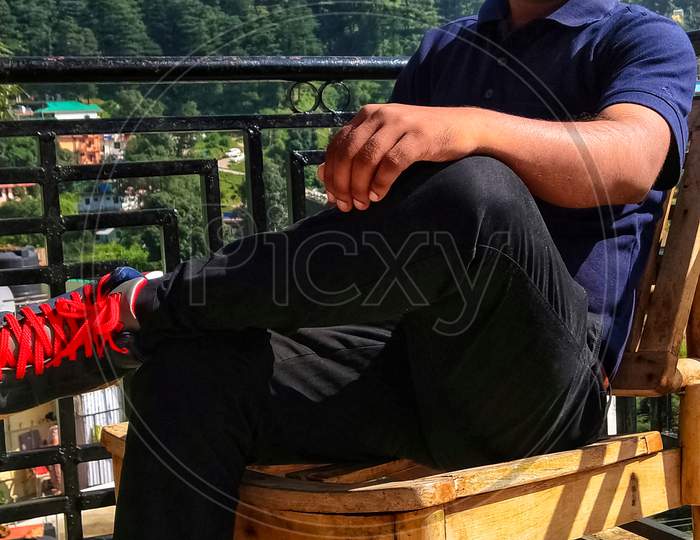 A guy enjoying holiday time in dharmshala in himachal pradesh india  a tourist place which is just below the huge mountain. Background blur selective focus.