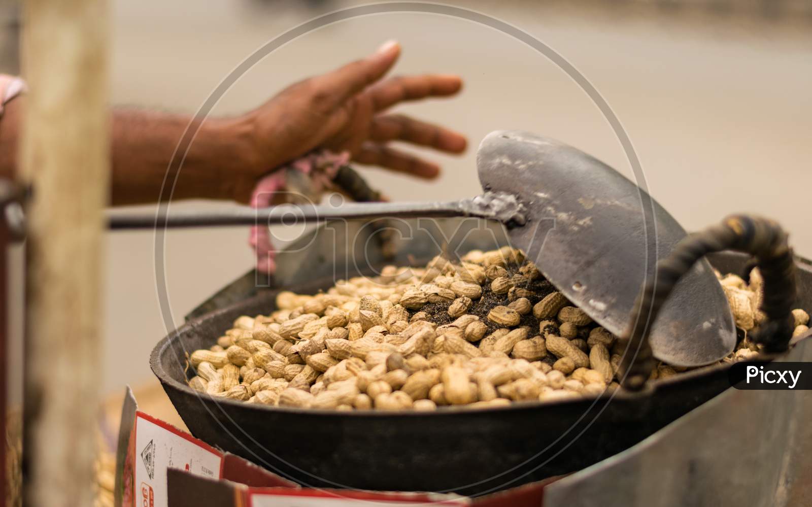 Peanuts Are Roasting Using Dry Sand On A Big Pan With A Big Spoon In Road Side
