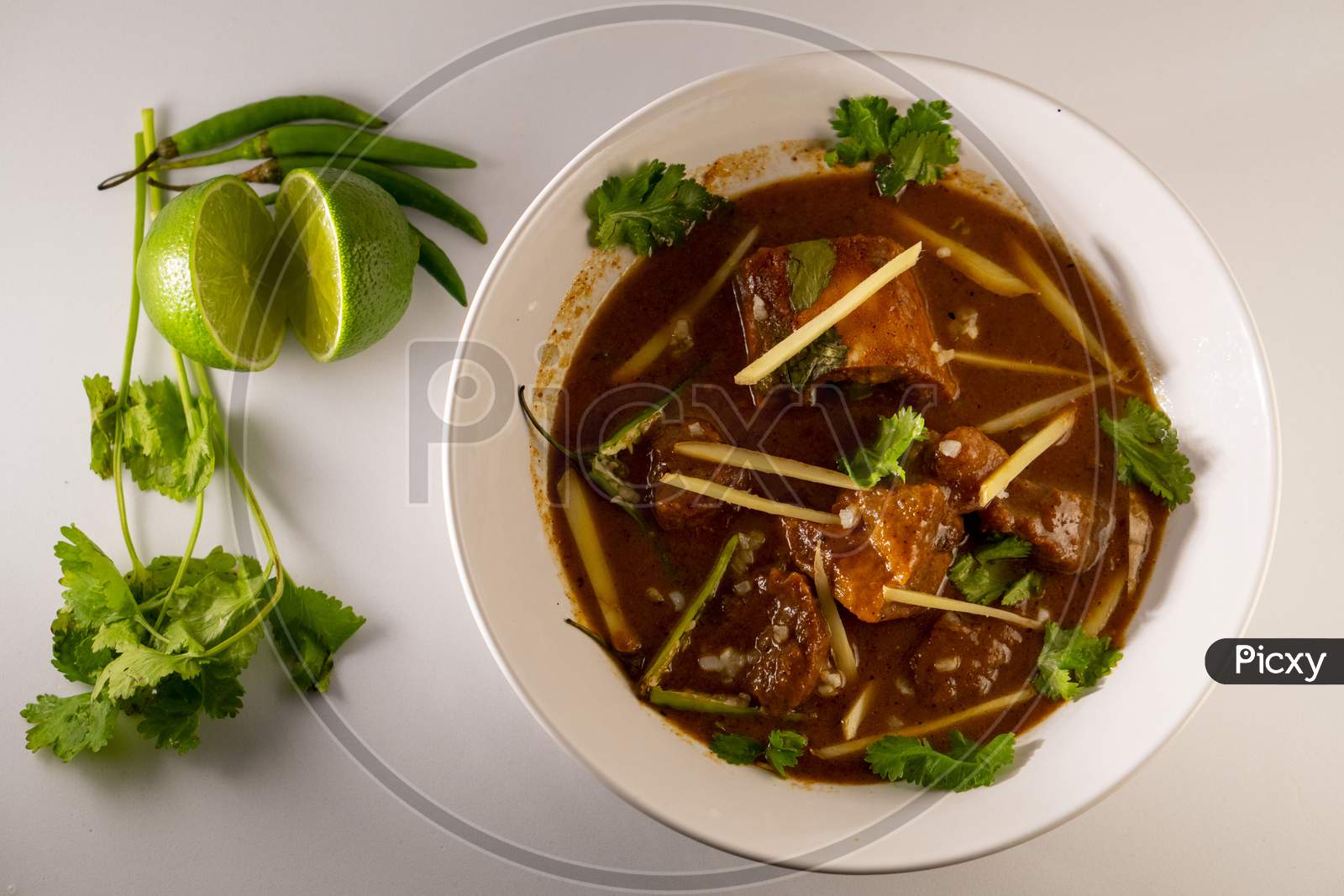 Top View of Mouth watering Beef Nihari Served with lemon, ginger, coriander and green chilli.