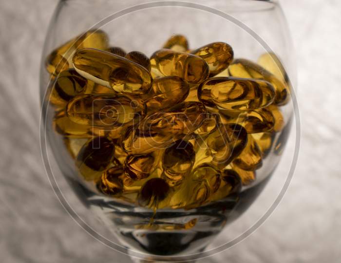 Omega-3 vitamins in a glass on a white background.