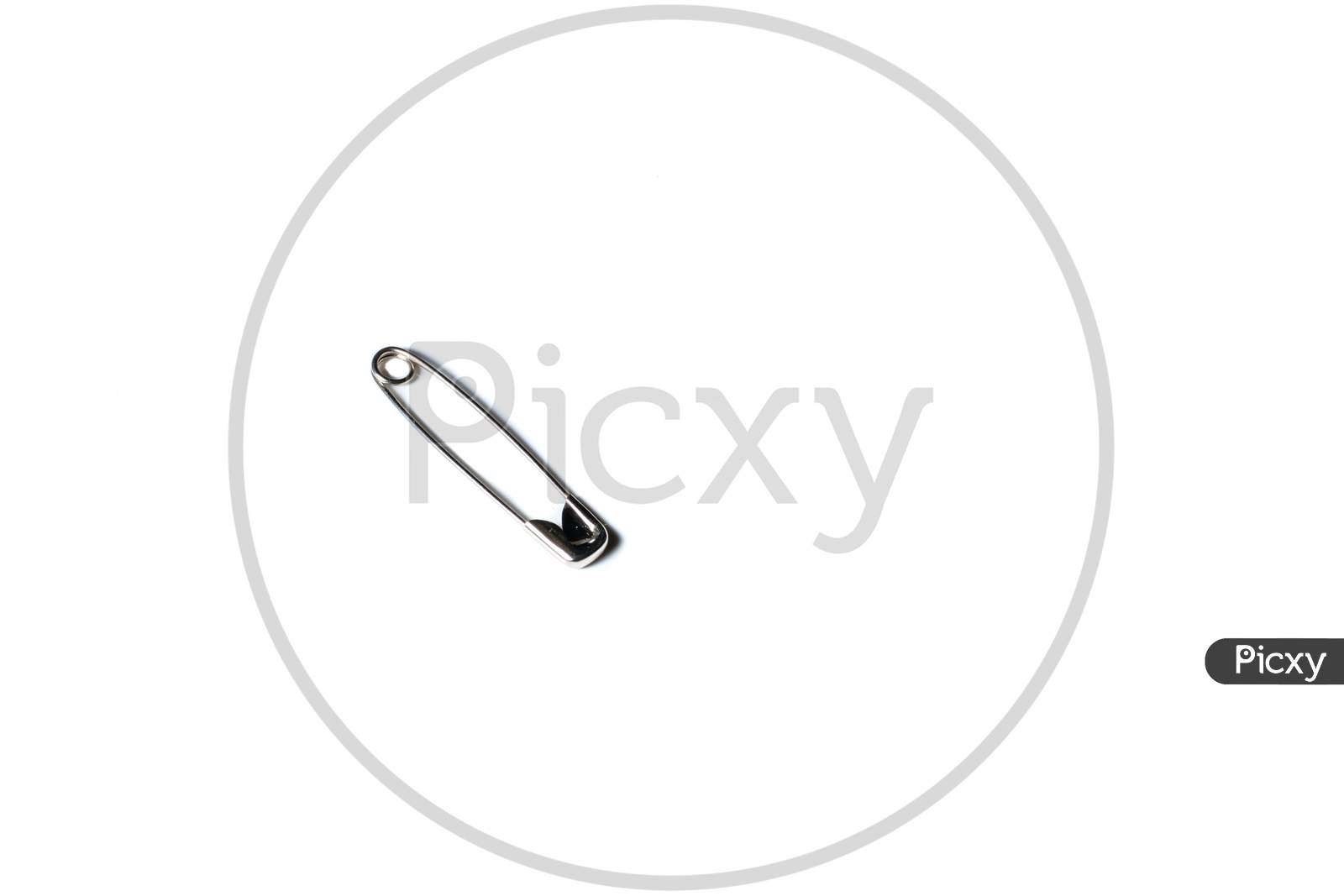 Isolated Safety Pin Placed On A White Background With Space For Text In The Right