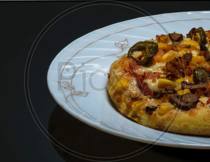 Vegetable Pizza Placed On A White Plate And Kept On A Black Table With Space For Text In The Left