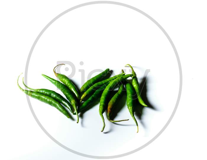 Isolated Green Chilis Placed In A White Background With Space For Text In The Right