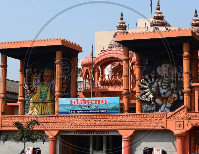 Idols of Goddess Saptashrungi and Lord Ganesha adorning the top of an entrance gate of a temple