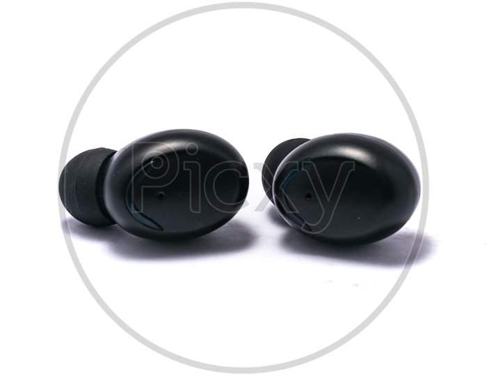A Pair Of Truly Wireless Earbuds On A Pure White Background With Shadows.
