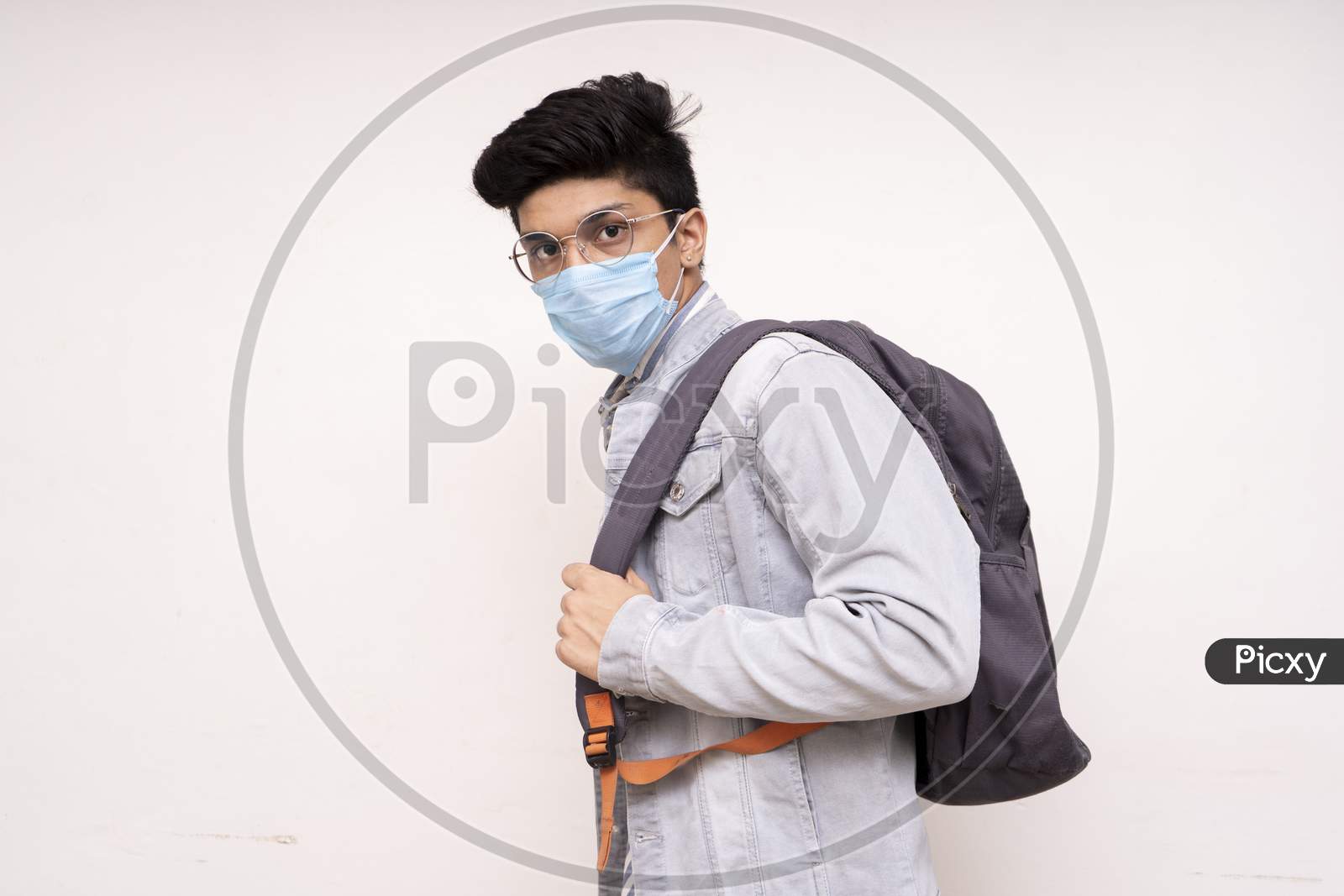 Young Handsome Asian Boy Ready For His College,Wearing A Mask, Bag On His Back, Looking Into The Camera.