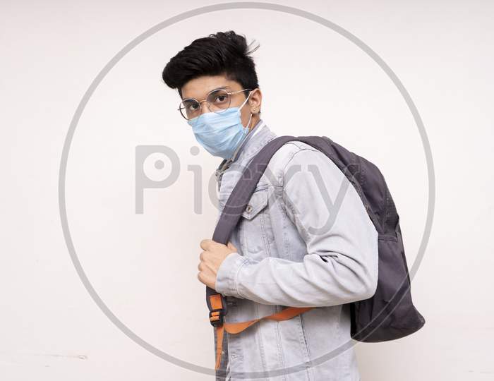 Young Handsome Asian Boy Ready For His College,Wearing A Mask, Bag On His Back, Looking Into The Camera.